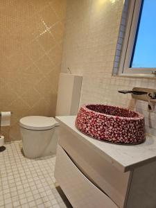 a bathroom with a toilet and a cake on a counter at Brentford house in Brentford +6 photos