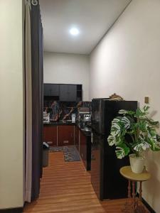 a kitchen with a black refrigerator and a potted plant at Papi Villa O3 in Tlekung