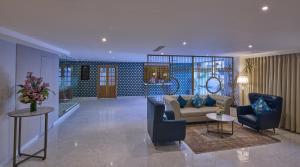 a living room with a couch and two chairs at Grand Continent T Nagar in Chennai
