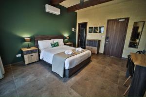 a bedroom with a large bed and green walls at 49 Sunrise Lodge in Għajnsielem