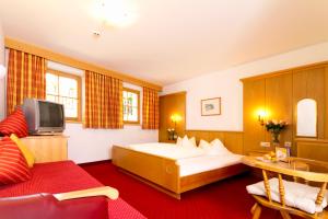 a hotel room with a bed and a tv at Biopension Alpenheim inkl SuperSommerCard in Fiss +37 photos