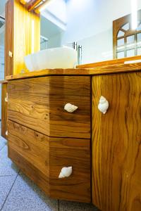 a wooden bathroom with a sink and a wooden dresser at Casa Paradiso Guest House in Costa Paradiso