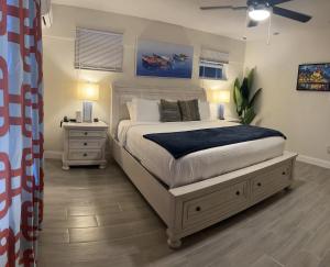 Un dormitorio con una cama y una mesita de noche con dos lámparas. en classic 4b2b FLL Home with heated pool, en Fort Lauderdale 34 fotos más