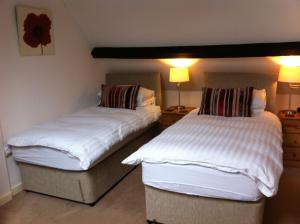 2 Betten nebeneinander in einem Zimmer in der Unterkunft Burcott Mill Guesthouse in Wells