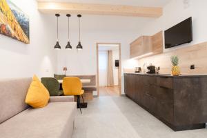 a living room with a couch and a kitchen at Residence Katrin in San Valentino alla Muta