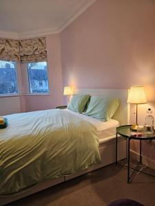 a bedroom with a bed with two lamps and a table at Brentford house in Brentford
