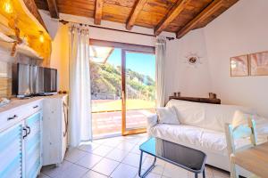 a living room with a couch and a tv at Casa Paradiso Guest House in Costa Paradiso