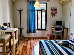 a bedroom with a bed and a desk and a window at 4 Rooms in Plovdiv