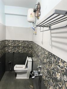 ラーンチーにあるAvante Palaceの黒と金の模様の壁、トイレ付きのバスルーム +43枚の写真