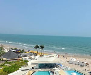 a view of a beach with a swimming pool and the ocean at Veranda by Welcome Hua Hin in Hua Hin