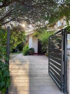 a black gate in front of a house at Exclusive Sardinian Villa 300 mt from the beach in Àrbatax