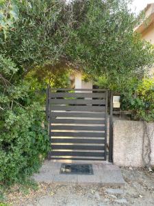 a gate in front of a building with a tree at Exclusive Sardinian Villa 300 mt from the beach in Àrbatax