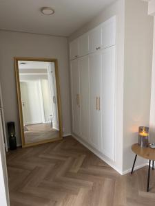 a room with white cabinets and a mirror at Short stay in the city center, free parking in Tampere +6 photos