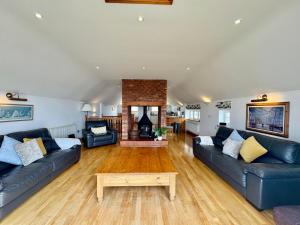 a living room with two couches and a fireplace at Porth House-Beach Front-3 Bed-3 Bath - SPA POOL and SAUNA in Trearddur