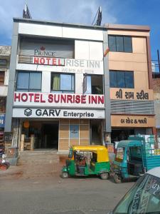 a hotel with two small vehicles parked in front of it at hotel sunrise inn in Ahmedabad