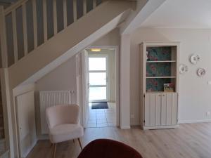 ein Wohnzimmer mit einem Stuhl und einer Treppe in der Unterkunft Le Repaire des Hirondelles - Le Schopf in Scharrachbergheim Irmstett