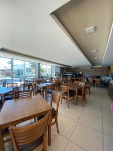 a restaurant with wooden tables and chairs and windows at Golden Lake Experiência Inesquecível 6 apto 301 in Arraial do Cabo +37 photos