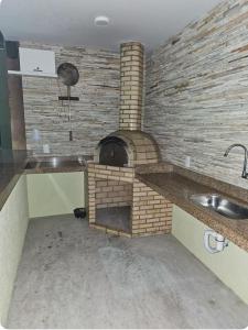 a kitchen with a brick oven with a sink at Golden Lake Experiência Inesquecível 6 apto 301 in Arraial do Cabo