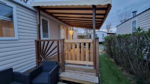 un porche de madera con toldo en una casa en Mobihome les sables du midi, en Valras-Plage