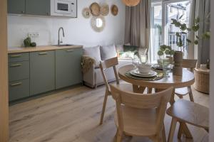 a kitchen and dining room with a table and chairs at Apartamenty Wyspa Jastarnia Oliwkowy in Jastarnia
