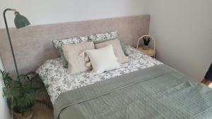 a bedroom with a bed with a green blanket and pillows at Apartamenty Wyspa Jastarnia Oliwkowy in Jastarnia +10 photos