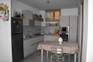 a kitchen with a table and a sink and a refrigerator at CASA della GIOIA in Caltagirone