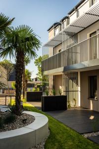 a palm tree in front of a building at Apartamenty Wyspa Jastarnia Oliwkowy in Jastarnia