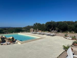 a swimming pool with chairs and tables at Casa Mariposa Porto Rotondo in Rudalza