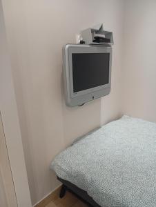 a tv sitting on a wall next to a bed at Apartament Zacisze in Częstochowa