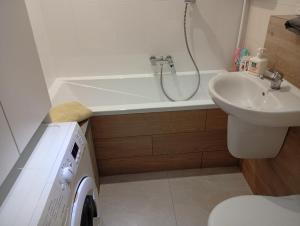 a bathroom with a tub and a sink and a toilet at Apartament Zacisze in Częstochowa +9 photos
