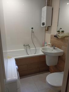 a bathroom with a sink and a toilet and a bath tub at Apartament Zacisze in Częstochowa