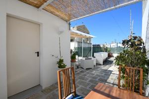 an outdoor patio with a door and chairs and plants at B&B CASAVACANZE CHIESA MADRE in Carovigno