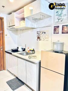 uma cozinha branca com uma pia e uma geladeira em Unit 33k studio em Cebu mais 2 fotografias
