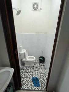 a bathroom with a toilet and a blue towel on the floor at Homestay Triangle Cottage Jerteh Besut in Jertih