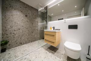a bathroom with a toilet and a glass shower at APARTIA apt Brno center in Brno +9 photos