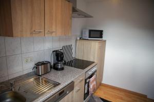 a small kitchen with a stove and a microwave at Ferienwohnung Bergblick O3 in Osterode