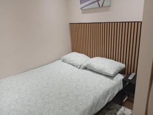a bedroom with a bed with two pillows on it at Apartament Zacisze in Częstochowa