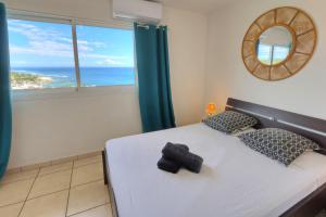 a bedroom with a bed with a view of the ocean at L'horizon - T2 Duplex - Vue mer à 180 in Saint-Gilles les Bains