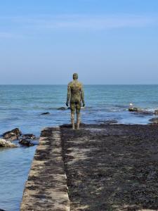 a man standing on a pier looking out at the ocean at Westbrook Lodge Guest House in Margate