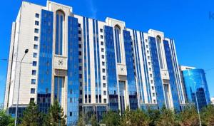 a large white building with blue windows and trees at ЖК Edel 1ком квартира комфорт набережная проспект Сарыарка in Astana