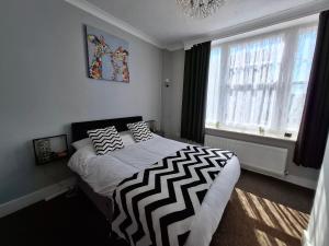 a bedroom with a bed with black and white pillows at Westbrook Lodge Guest House in Margate