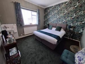a bedroom with a bed and a large window and a bed sidx sidx at Westbrook Lodge Guest House in Margate