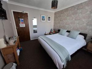 a bedroom with a large white bed in a room at Westbrook Lodge Guest House in Margate