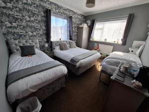 a small bedroom with two beds and a window at Westbrook Lodge Guest House in Margate