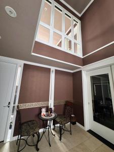 a room with a table and chairs and a window at BIEI TERRACE 1st Floor - 1F専用独立玄関 - 1F占有78平米大型ワンルーム- ソファベッド7台, 170型米Valerion社製最新シアター動画視聴, 無料Wi-Fi, シャワー, ミニキッチン付き - 駅前通り沿い - in Biei