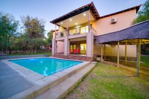 a house with a swimming pool in front of it at Mshengu Kruger Lodge in Marloth Park