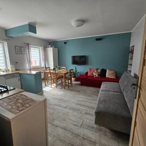 a kitchen and living room with a couch and a table at Apartament "Przy Jeziorku" in Kętrzyn