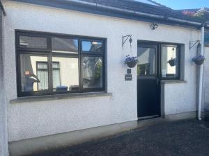 a man standing outside of a house with a door at Beechwood Lodges in Ballycastle