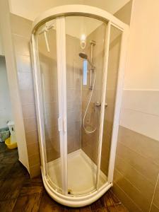 a shower with a glass door in a bathroom at Sottovento Central Apartment in Levanto