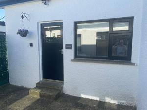 a person sitting in a window next to a door at Beechwood Lodges in Ballycastle +20 photos